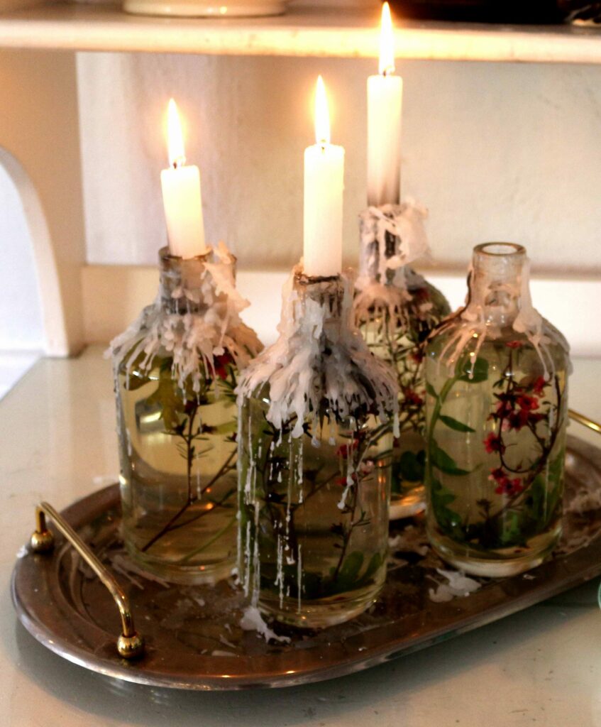 Candles in glass bottles melting in greyton
