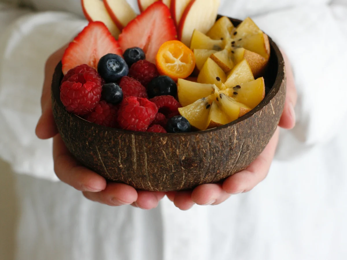 A bowl of fruit held by server.