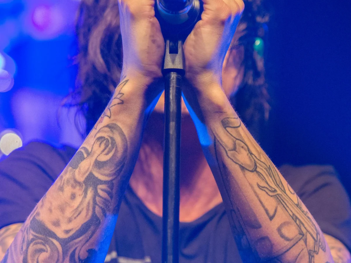 Tattooed man singing into microphone